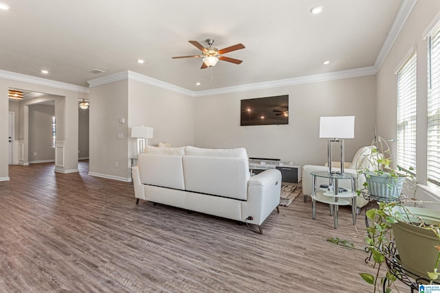 living room featuring dark hardwood / wood-style flooring, crown molding, ceiling fan, and a healthy amount of sunlight