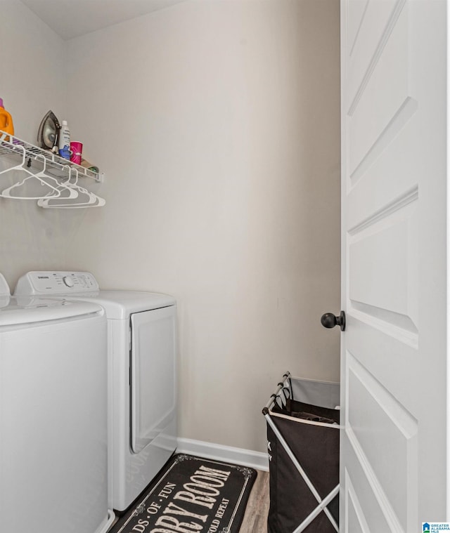 clothes washing area featuring washer and clothes dryer and hardwood / wood-style floors