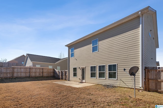 back of property with a yard and a patio