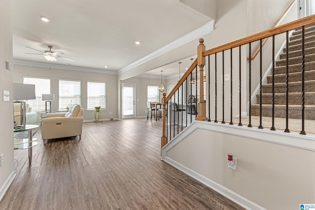 interior space with ceiling fan, ornamental molding, and hardwood / wood-style flooring