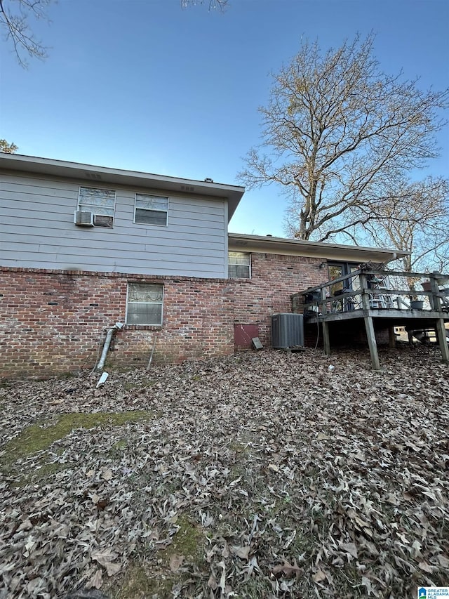 view of side of property featuring central air condition unit and a wooden deck