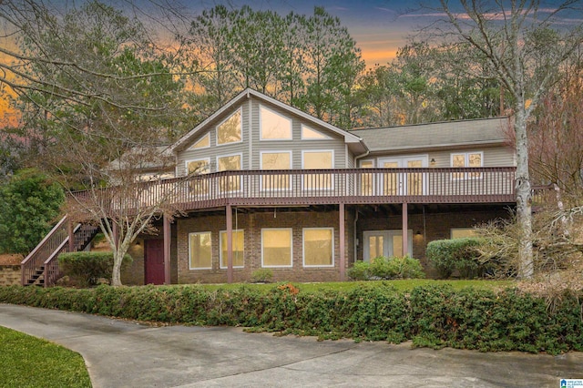 back house at dusk featuring a deck