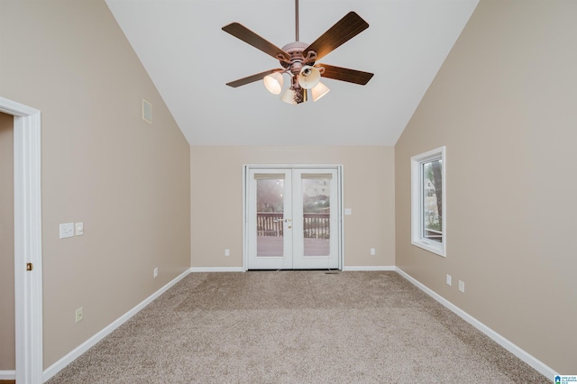 carpeted spare room with ceiling fan, high vaulted ceiling, and french doors