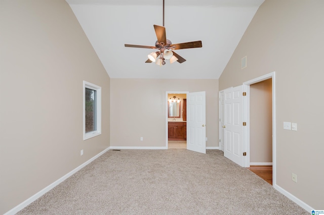 spare room with light carpet, high vaulted ceiling, and ceiling fan