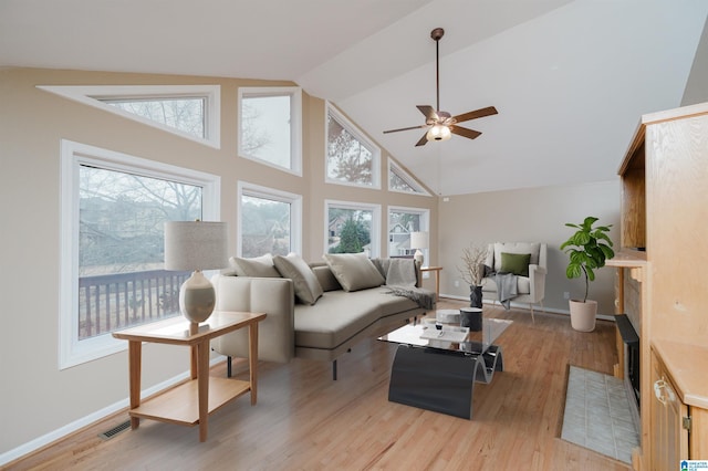 living room featuring high vaulted ceiling, light hardwood / wood-style flooring, and ceiling fan