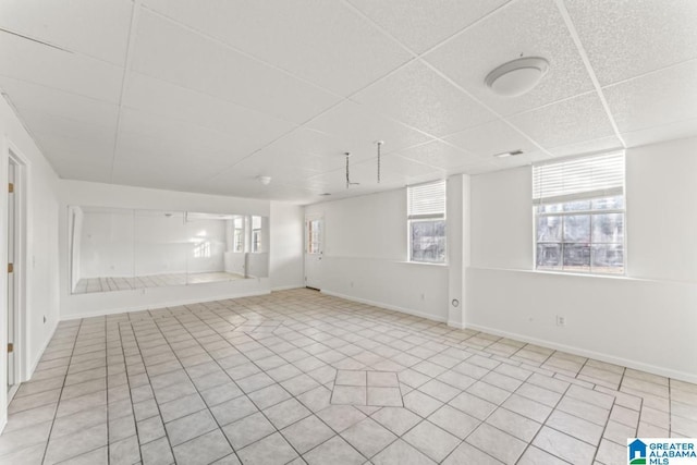 unfurnished room featuring light tile patterned floors and a drop ceiling