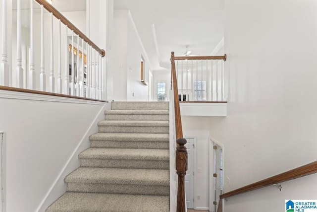 stairway featuring ceiling fan