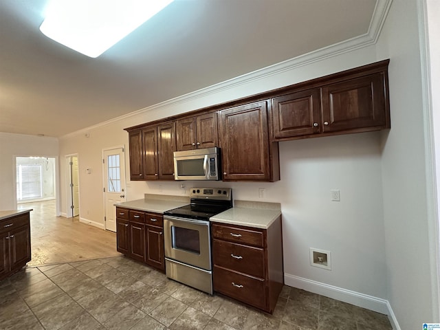 kitchen with dark brown cabinetry, ornamental molding, and stainless steel appliances