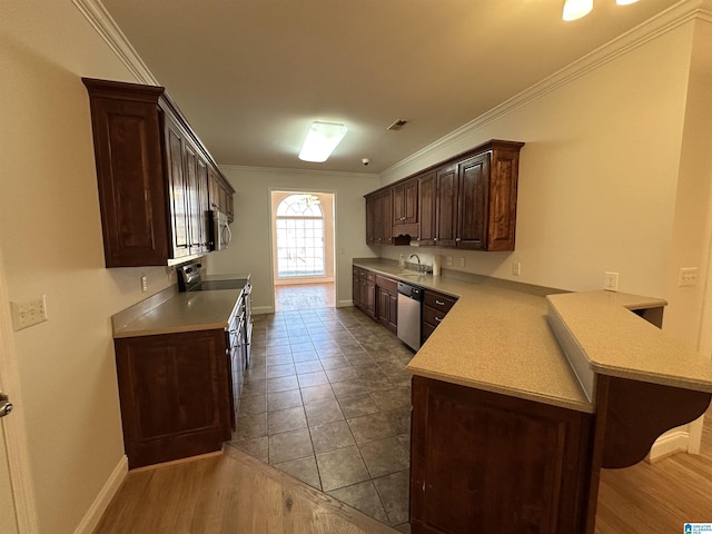 kitchen with dark brown cabinets, stainless steel appliances, light wood-type flooring, and ornamental molding