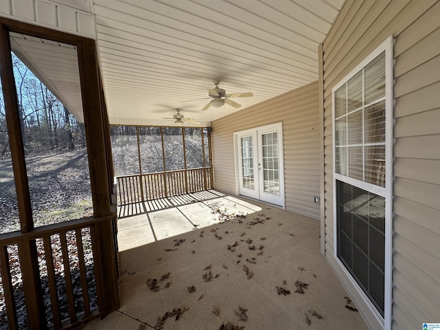 unfurnished sunroom with ceiling fan