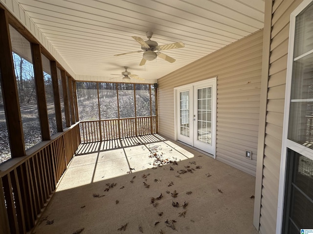 unfurnished sunroom featuring ceiling fan and french doors