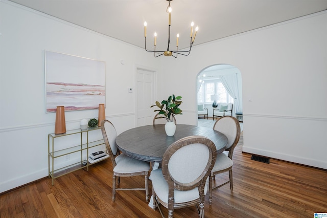 dining area with a chandelier, dark hardwood / wood-style flooring, and ornamental molding