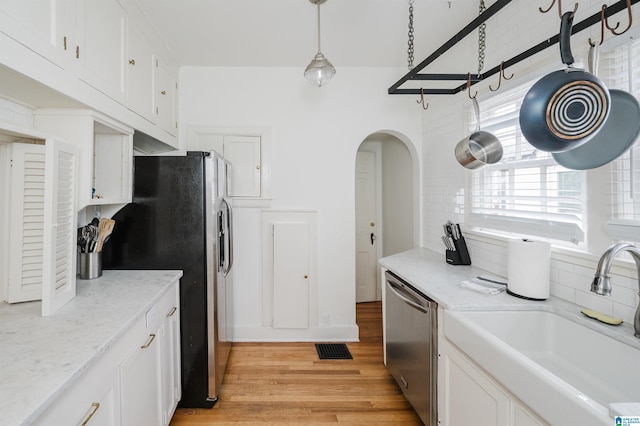 kitchen with light hardwood / wood-style flooring, stainless steel appliances, white cabinetry, and sink