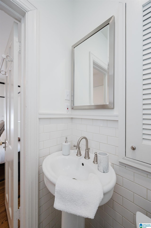 bathroom featuring tile walls and sink