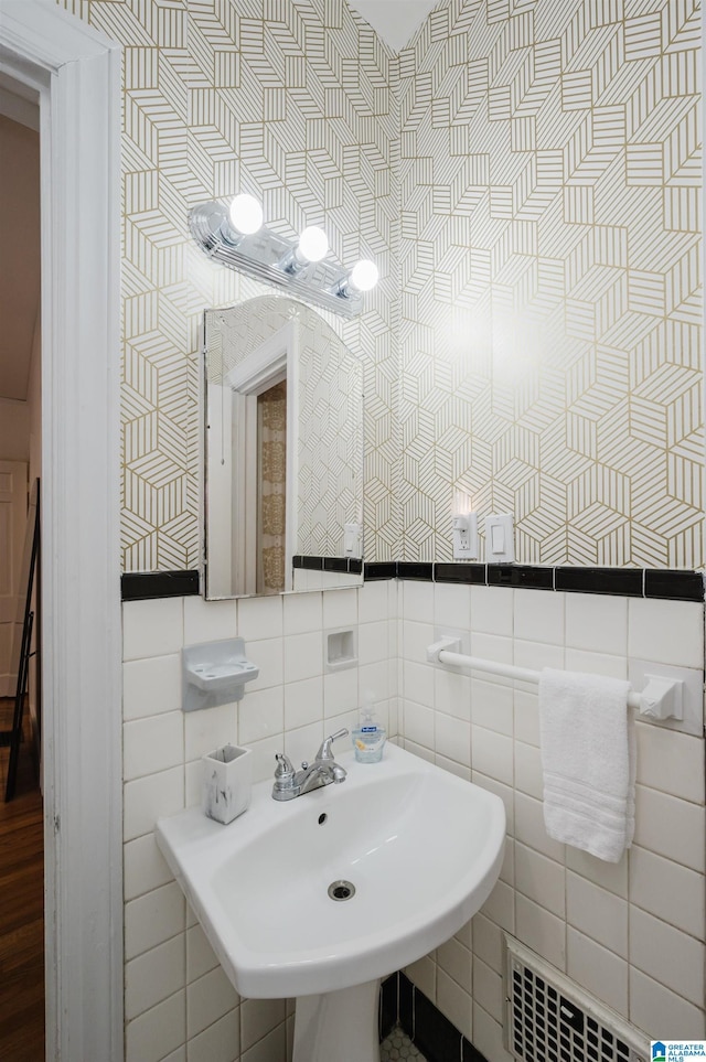 bathroom with radiator, sink, and tile walls