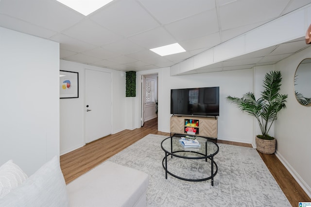 living room featuring a paneled ceiling and hardwood / wood-style floors