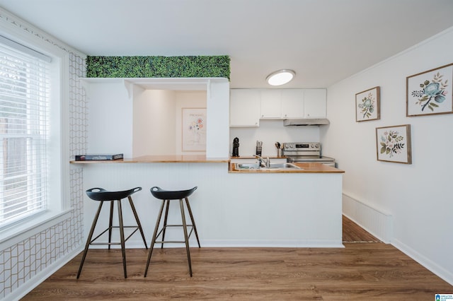 kitchen featuring kitchen peninsula, sink, wood-type flooring, electric range, and white cabinetry