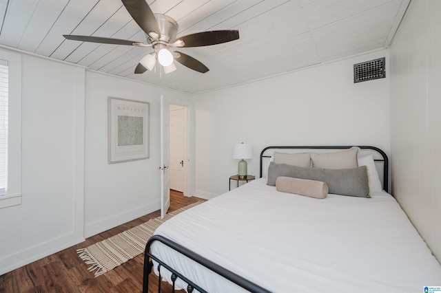 bedroom with ceiling fan, dark hardwood / wood-style flooring, and wood ceiling