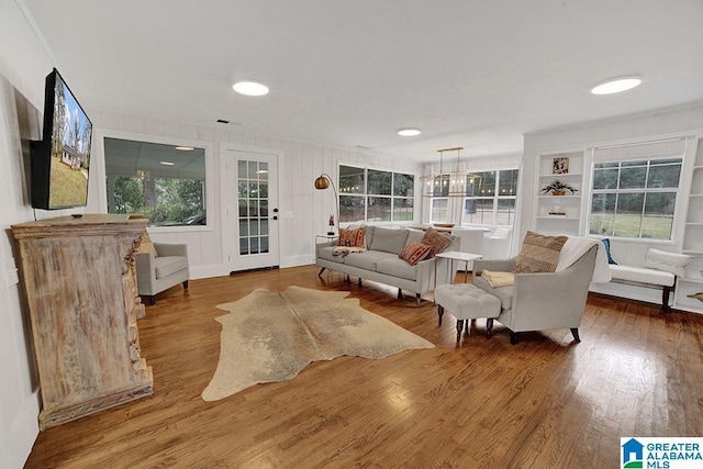 living room featuring a chandelier, wood-type flooring, and a healthy amount of sunlight