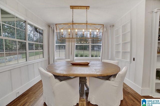 dining room with dark hardwood / wood-style floors, crown molding, and an inviting chandelier