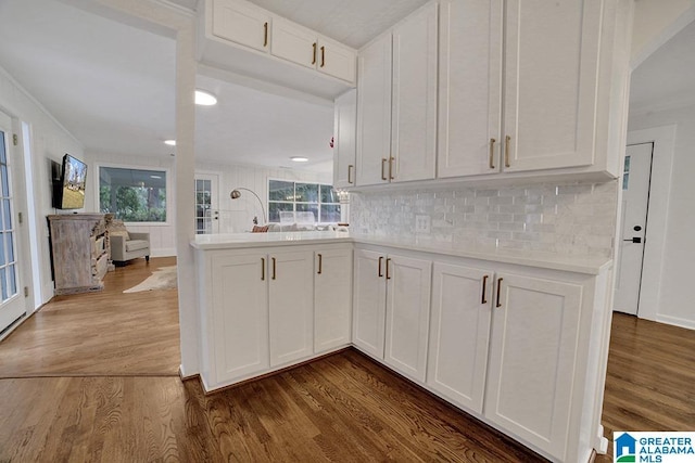 kitchen featuring kitchen peninsula, white cabinets, a wealth of natural light, and dark wood-type flooring