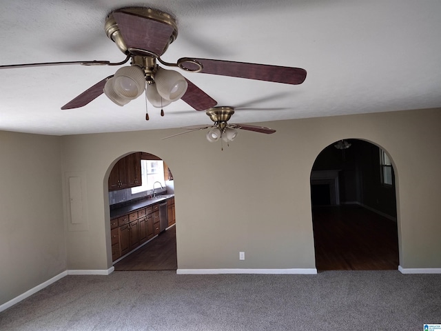 carpeted empty room featuring ceiling fan and sink