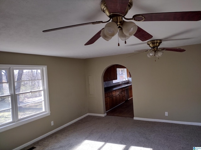 carpeted empty room featuring ceiling fan and sink