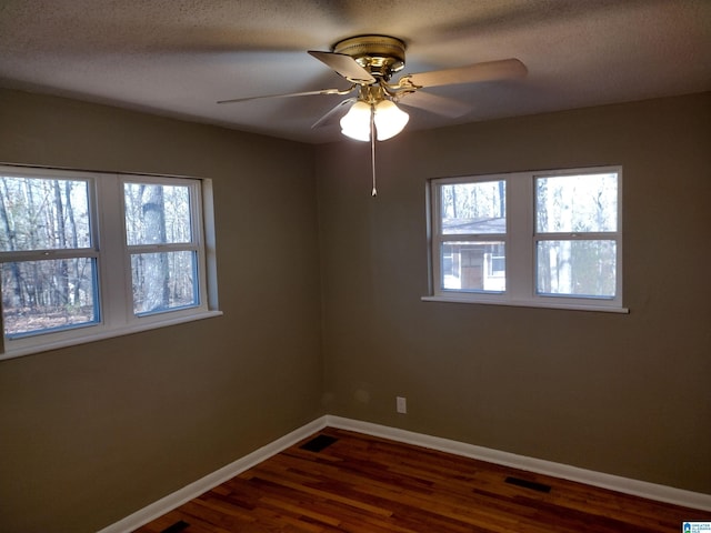 unfurnished room featuring dark hardwood / wood-style floors, ceiling fan, and a textured ceiling