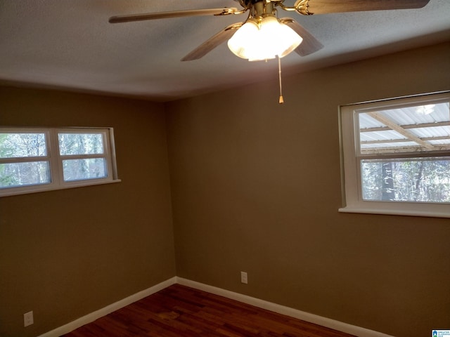 unfurnished room with dark hardwood / wood-style floors and ceiling fan