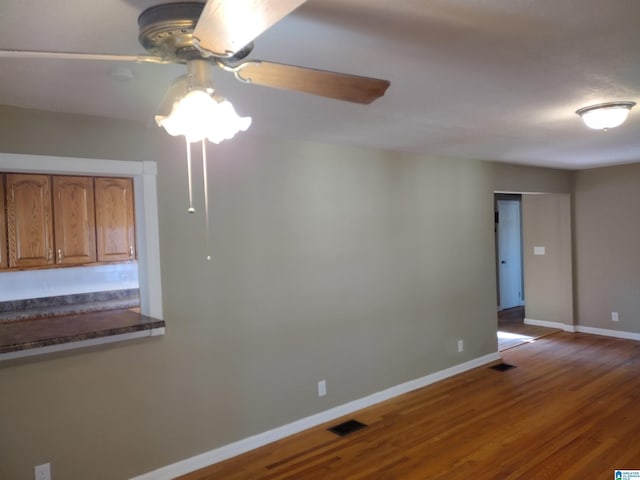 empty room with hardwood / wood-style flooring and ceiling fan