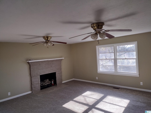 unfurnished living room featuring carpet, a stone fireplace, and ceiling fan