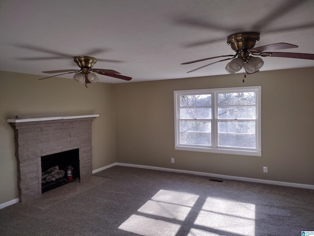 unfurnished living room featuring ceiling fan, a stone fireplace, and carpet floors