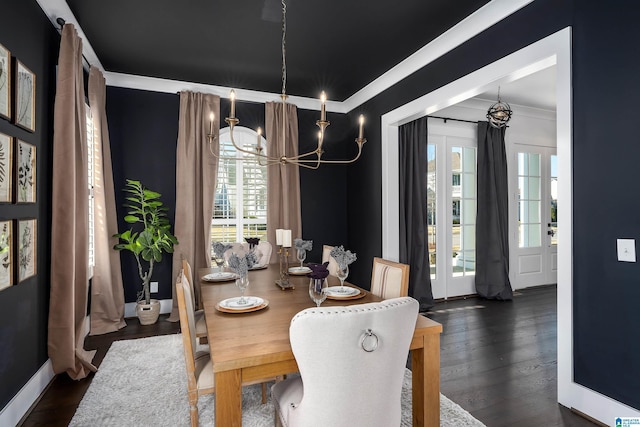 dining area with dark hardwood / wood-style flooring, an inviting chandelier, and ornamental molding