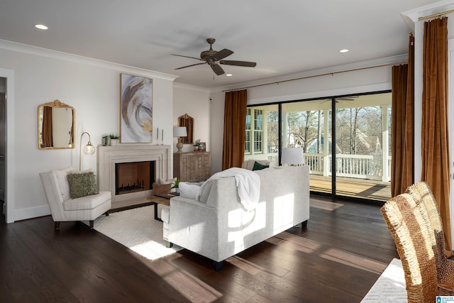 living room featuring dark wood-type flooring, ceiling fan, and ornamental molding