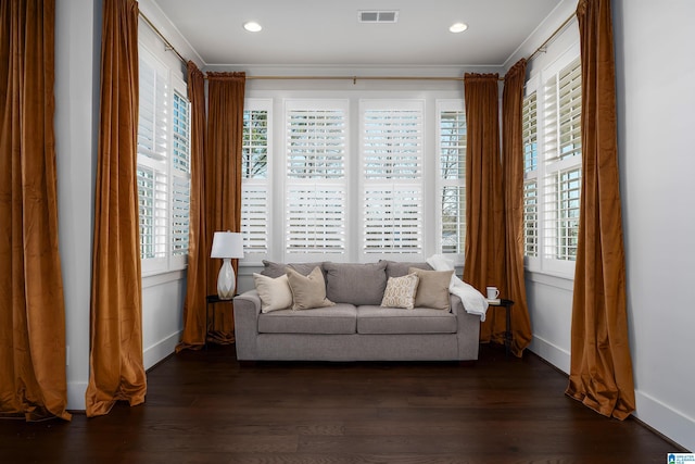 living area featuring dark hardwood / wood-style flooring, a healthy amount of sunlight, and ornamental molding