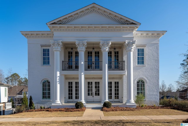 neoclassical / greek revival house featuring a balcony and french doors