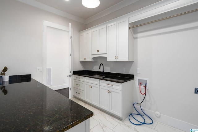 kitchen with crown molding, sink, white cabinets, and dark stone counters