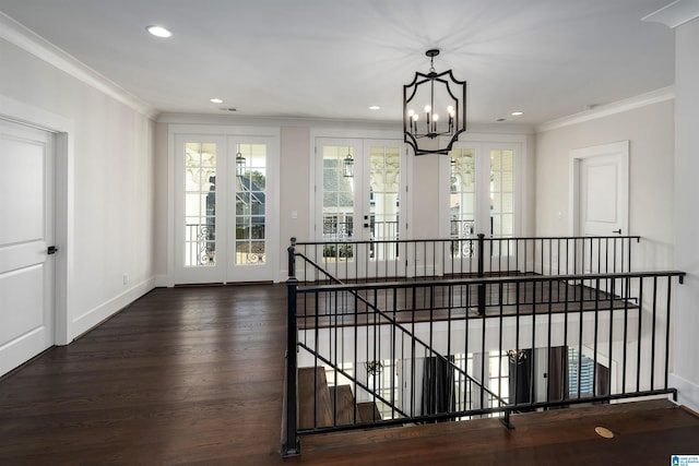 interior space with a chandelier, french doors, crown molding, and hardwood / wood-style floors