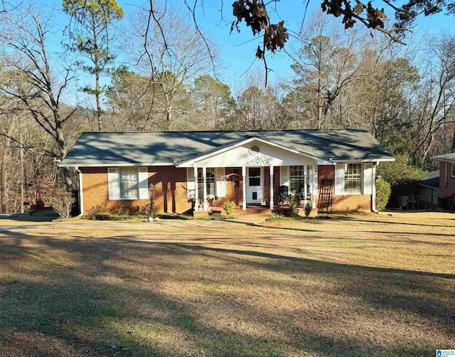 ranch-style house featuring covered porch and a front yard