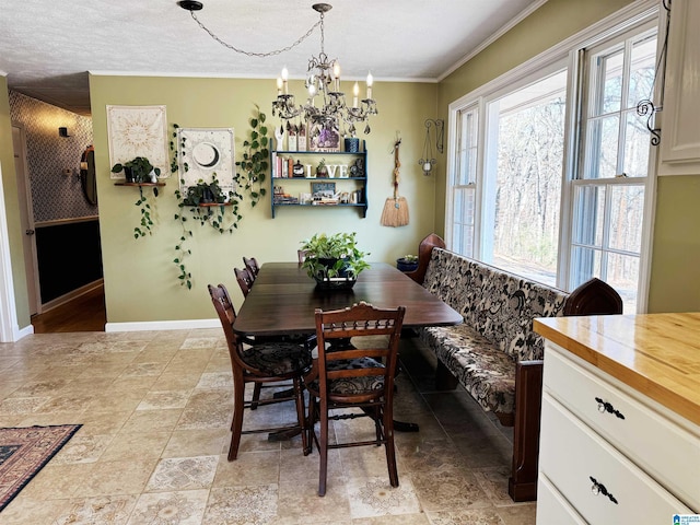 dining space featuring ornamental molding and a notable chandelier