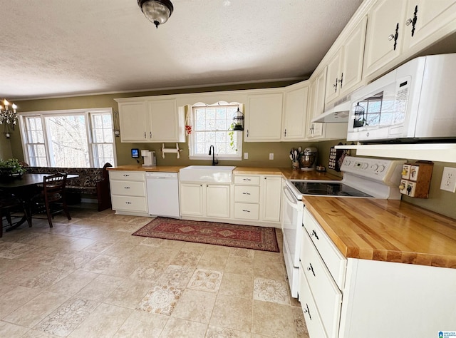 kitchen featuring white cabinets, wood counters, white appliances, and sink