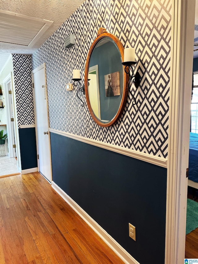 hall with hardwood / wood-style flooring and a textured ceiling