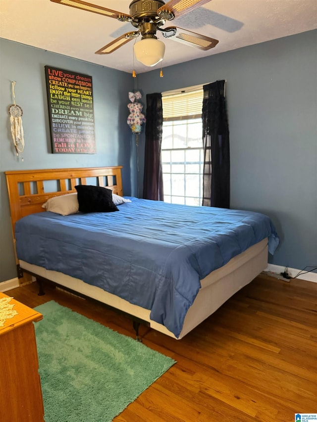 bedroom with ceiling fan and hardwood / wood-style flooring