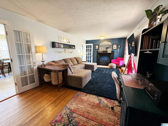 living room featuring hardwood / wood-style floors, a textured ceiling, and french doors