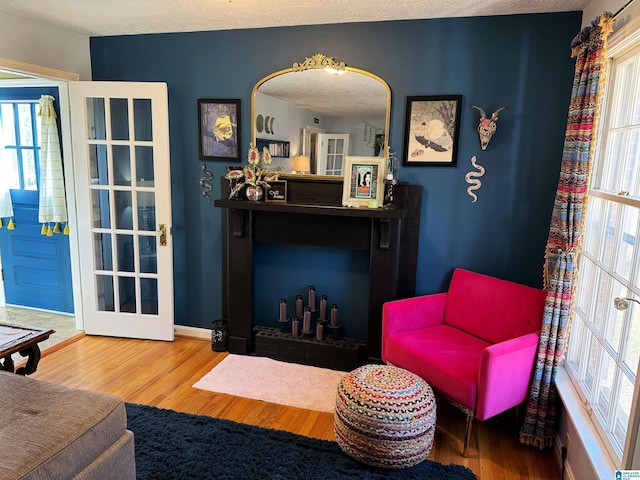 living area with wood-type flooring and a textured ceiling