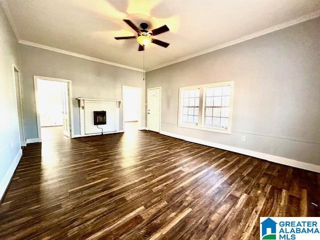 unfurnished living room with a fireplace, dark hardwood / wood-style floors, ceiling fan, and crown molding