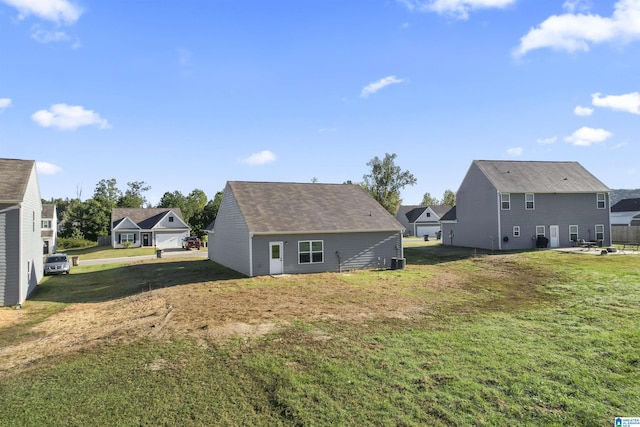 back of house with cooling unit, a yard, and an outbuilding