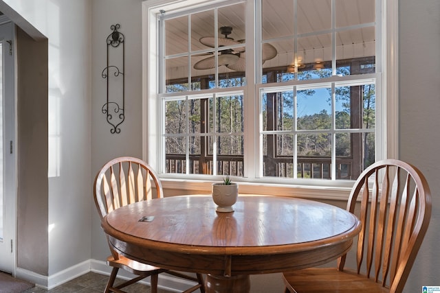 tiled dining room featuring ceiling fan and a healthy amount of sunlight