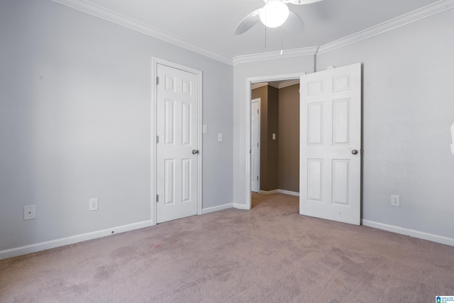 carpeted spare room featuring ceiling fan and ornamental molding