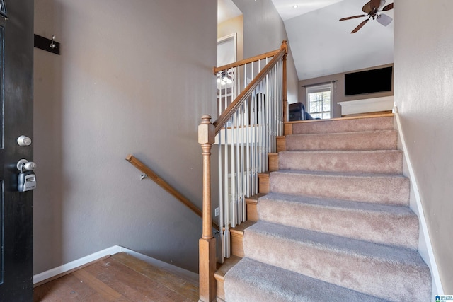 stairway with ceiling fan, hardwood / wood-style flooring, and vaulted ceiling